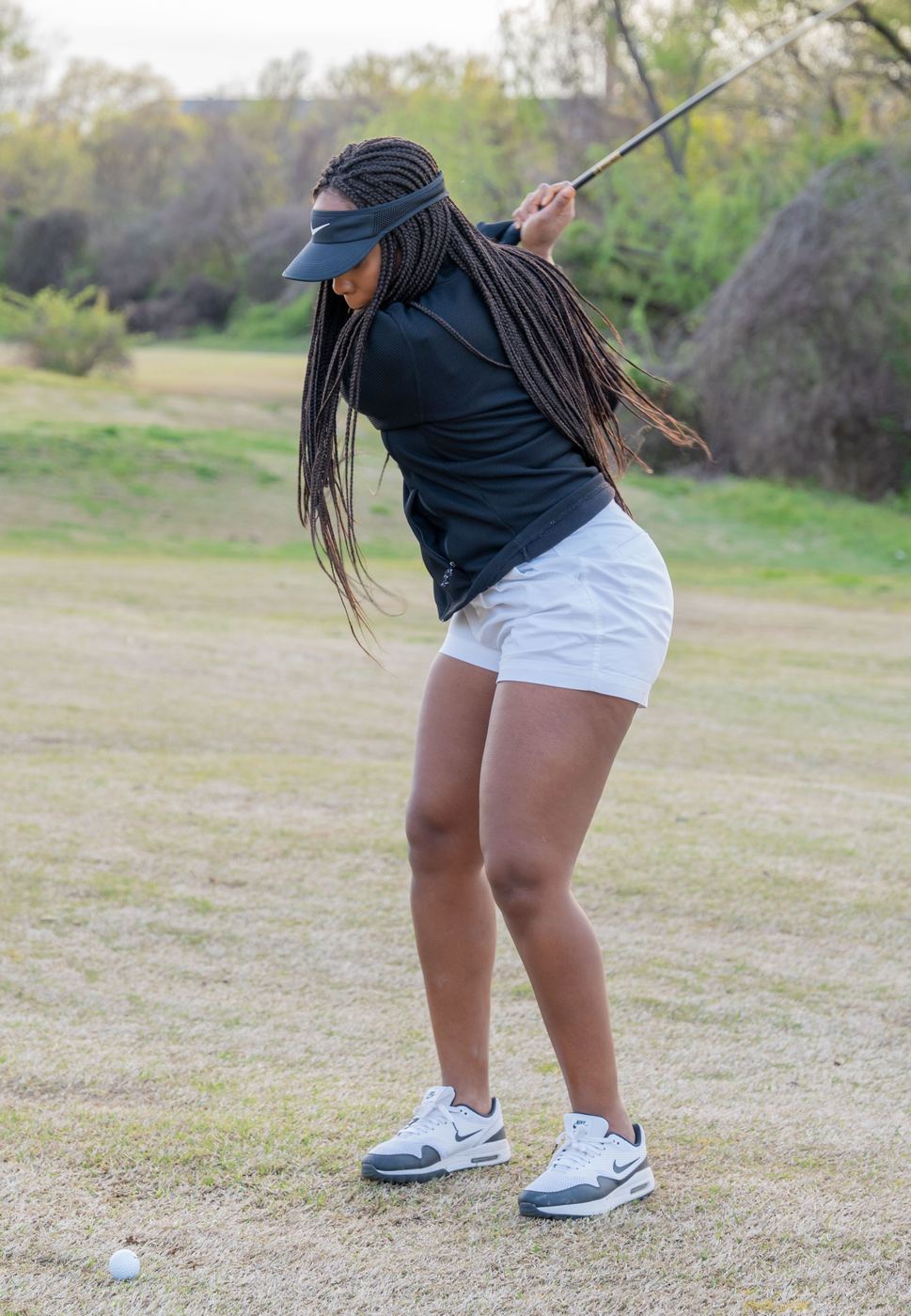 Golfer at the top of her backswing