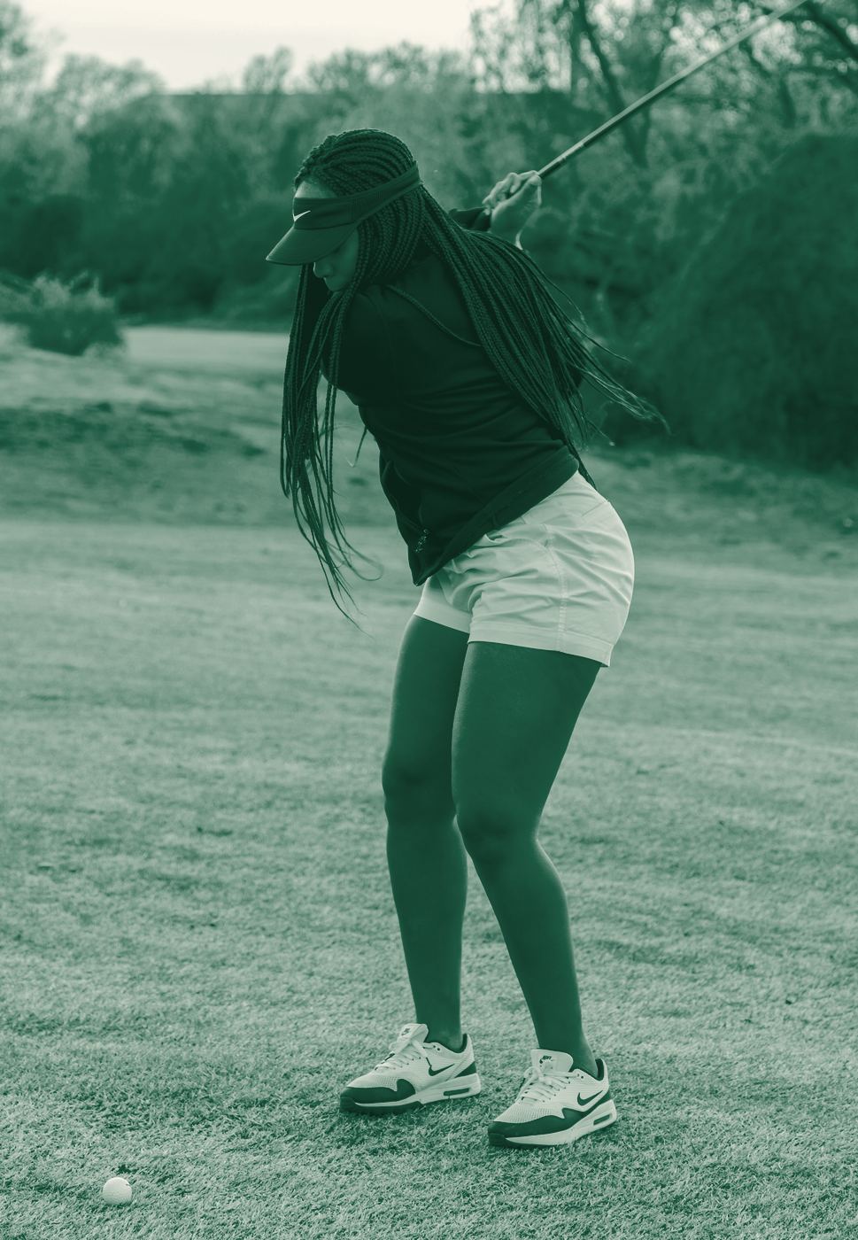 Young golfer at the top of her backswing
