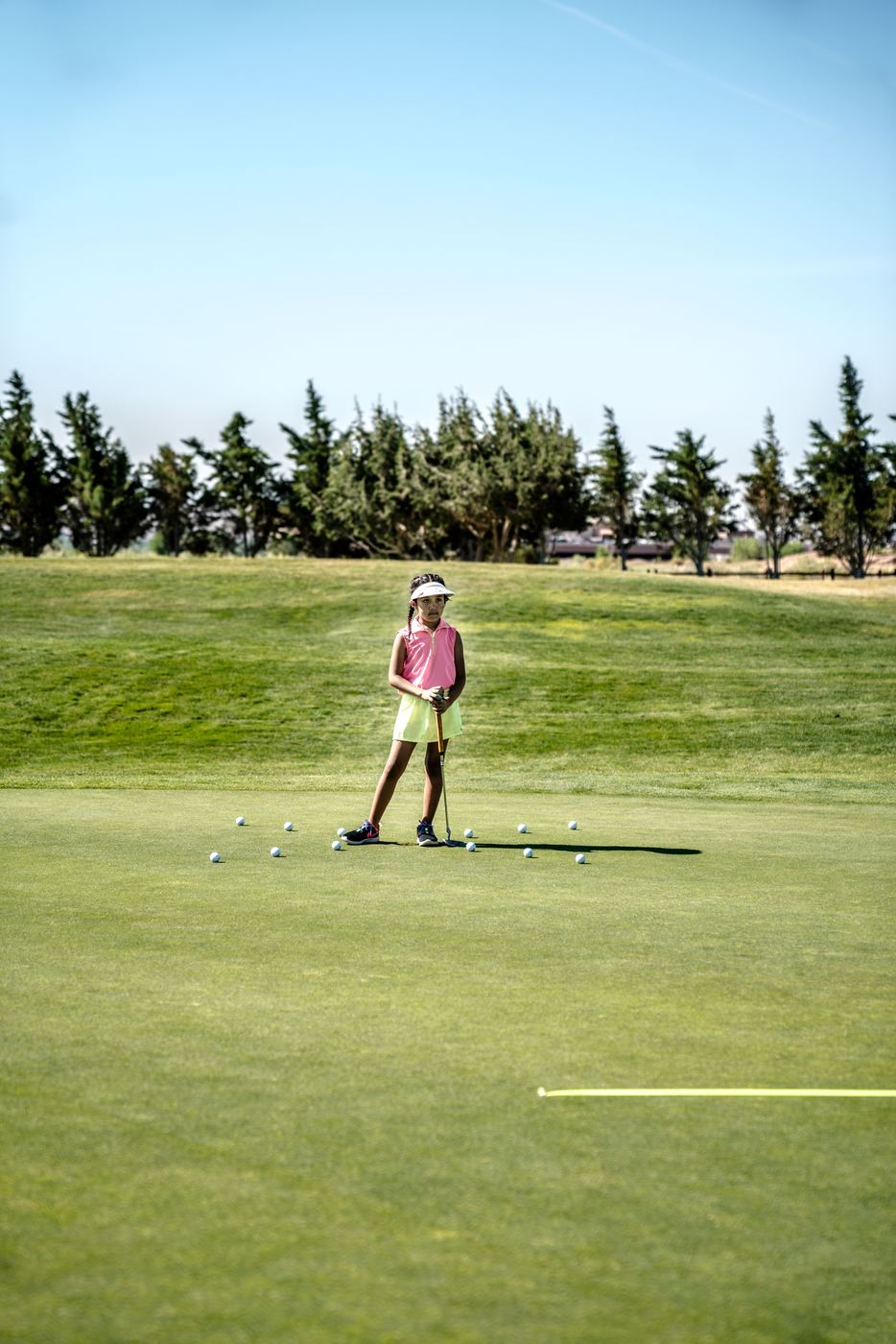 Young player practising putting on the green