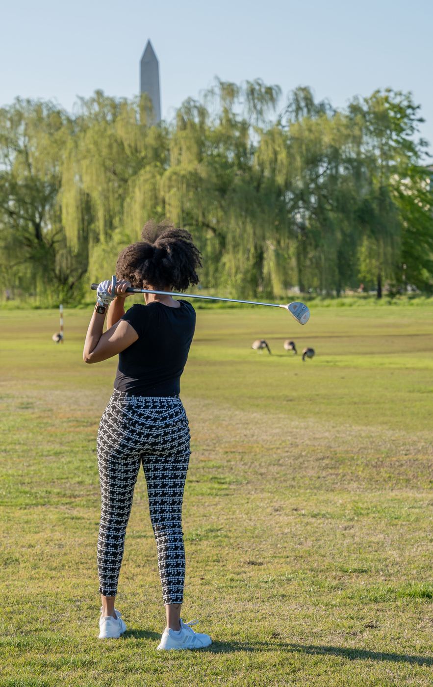 Golfer watching her drive from the tee